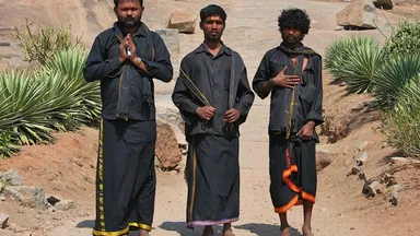 Ayyappa devotees in traditional black pilgrimage attire on the path to Sabarimala